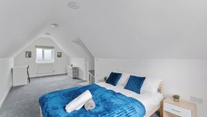 Ein Schlafzimmer mit Bett, Nachttisch und Fenster.