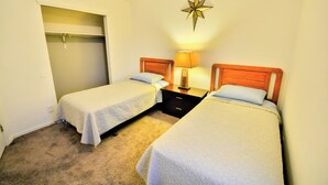 A bedroom with two single beds, a closet, and a star-shaped wall decoration.