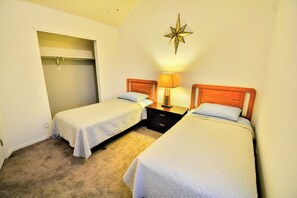 A bedroom with two single beds, a closet, and a star-shaped wall decoration.