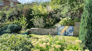 A garden with a variety of plants and a mosaic-tiled wall. - 2BD Garden Hideaway in Lewes (Lewes)
