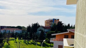 A residential area with various buildings, including a multi-story apartment complex and single-family homes. - Nova City Center - 217 (Divjakë)