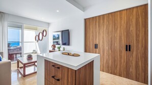 Una cocina moderna con una isla central, armarios de madera y un amplio vestidor de madera.
