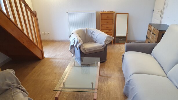 A living room with a glass-top coffee table, a sofa, a chair, and a wooden cabinet. - Quiet house close to all amenities and train station (Chauffailles)