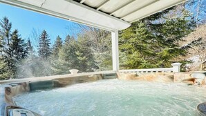A hot tub with a view of a forested area.