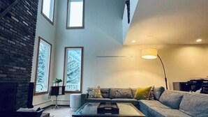 A spacious living room with a fireplace, a large window, and a modern sofa.