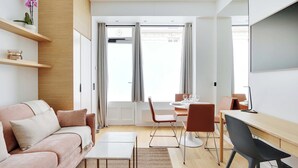 A modern living room with a sofa, coffee table, and dining area. - Charming Apt - 1bd/4p - Invalides/bon Marche (Paris)