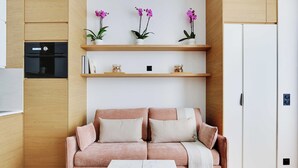A modern living room with a sofa, a coffee table, and decorative shelves with flowers. - Charming Apt - 1bd/4p - Invalides/bon Marche (Paris)