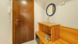 Una puerta de madera con un ojo de cerradura y un teléfono en la pared.