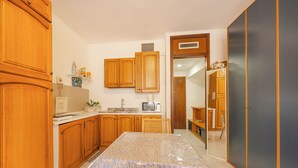 Una cocina con armarios de madera, un microondas y un lavamanos.