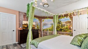Een slaapkamer met een hemelbed, een dressoir en uitzicht op een tuin door een glazen deur.