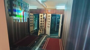 A hallway with a marble floor, a red carpet, and a wall with a colorful, abstract design. - HS STIDUS 1 (Giza)