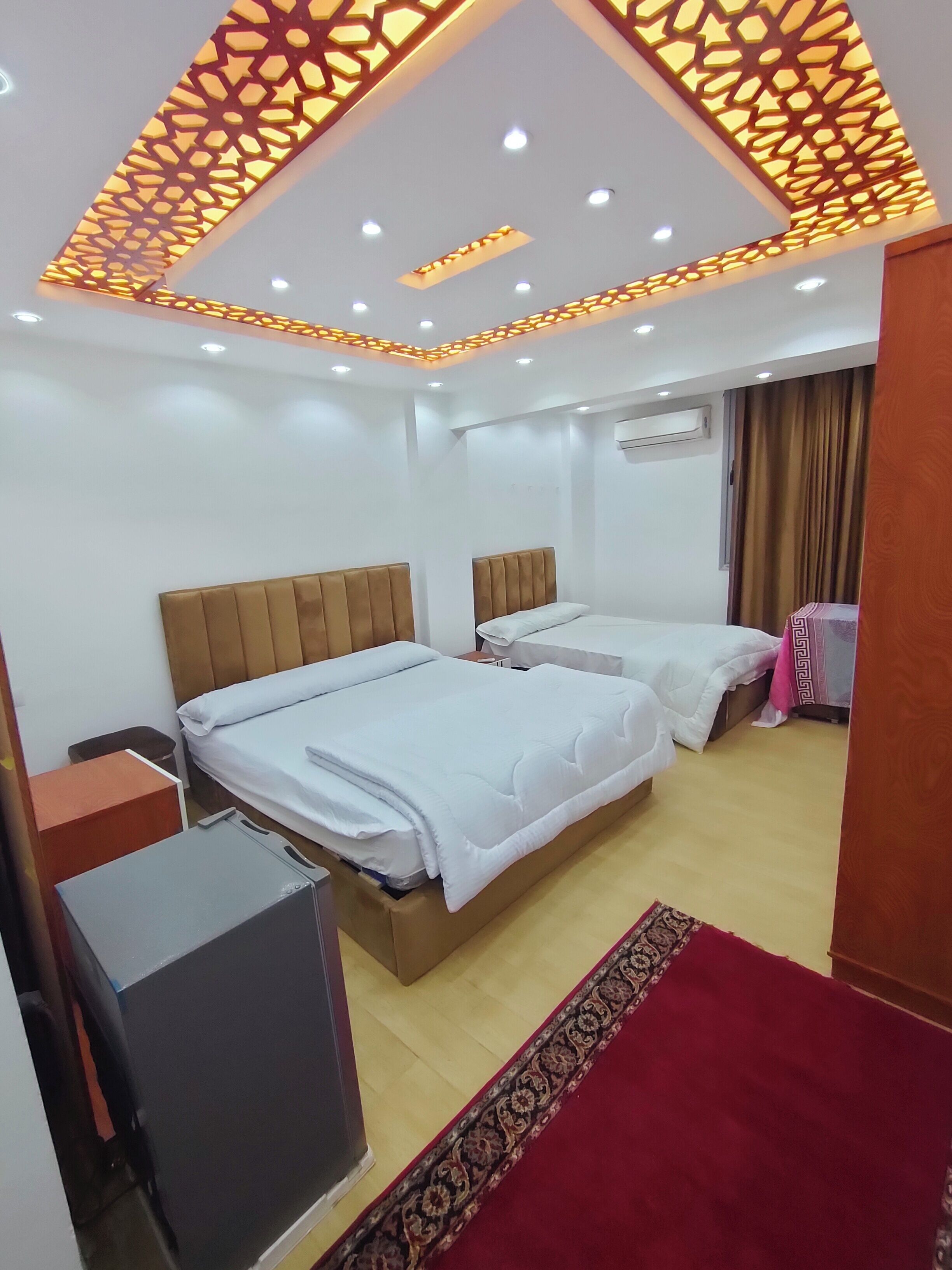 Habitación de hotel con dos camas, un escritorio y una televisión.