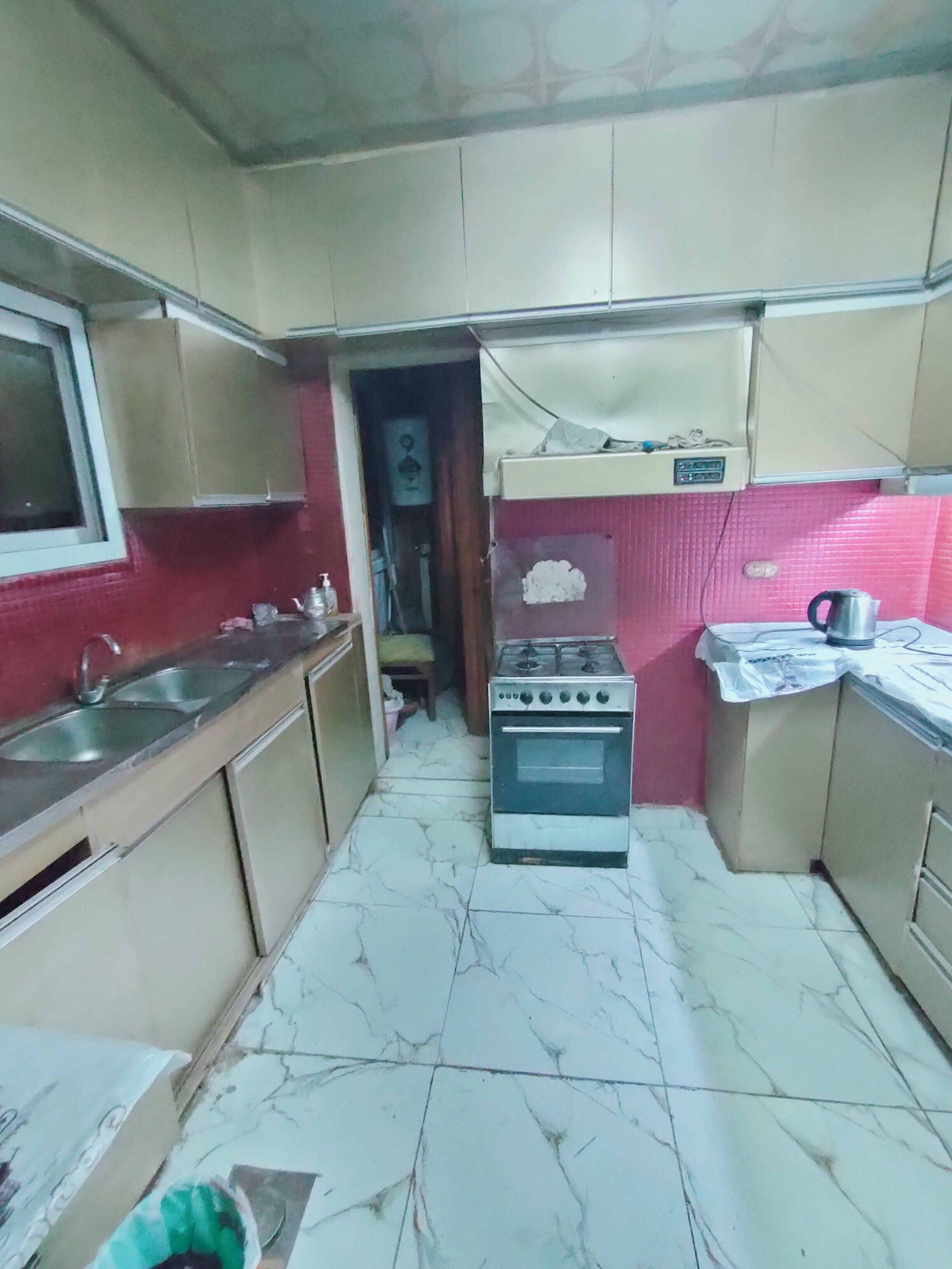 Una cocina funcional con estufa a gas, lavamanos y armarios.