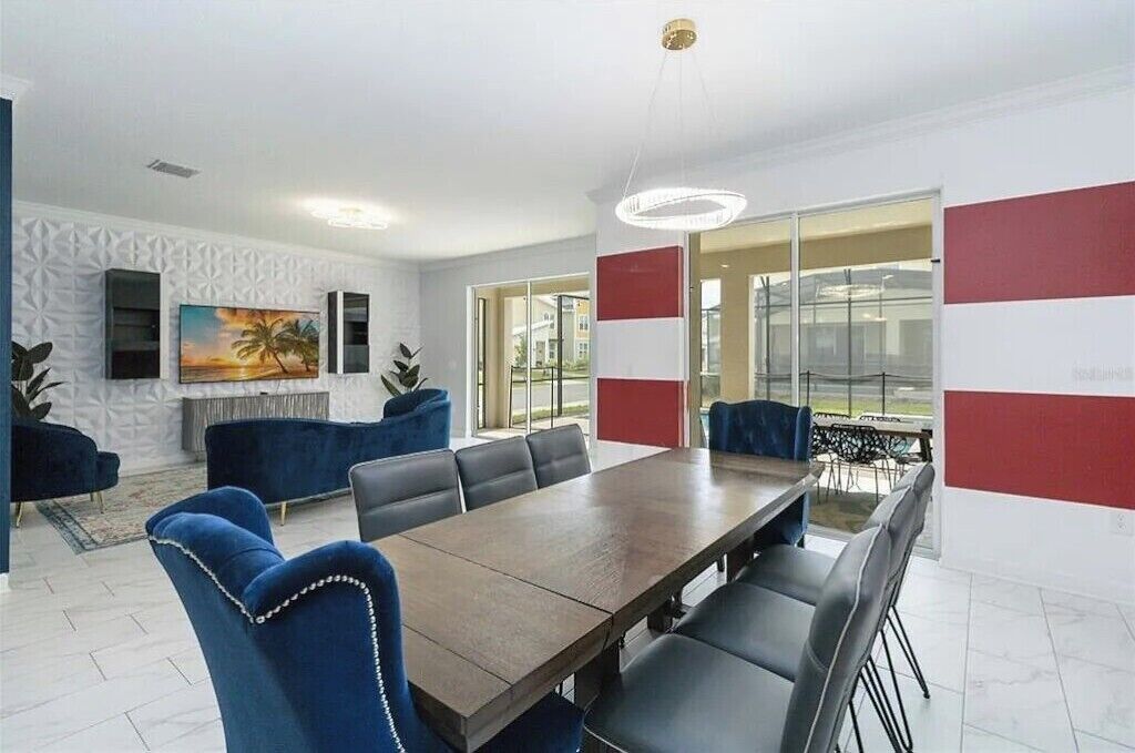 Une salle de conférence moderne, dotée d’une longue table et de chaises recouvertes d’un tissu bleu, d’un grand tableau accroché au mur et offrant une vue dégagée grâce à de larges fenêtres.