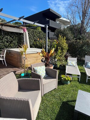 A patio area with wicker furniture, a wooden bench, and potted plants. - Vacation home in Antibes (Antibes)