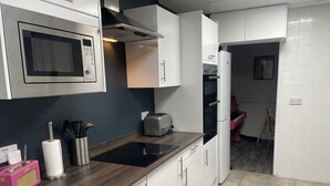 A modern kitchen with white cabinets, a stainless steel microwave, a toaster, and a built-in oven. - Magenta Melodies, 5 bedroom house with 2 free parking spaces  (Blackpool)