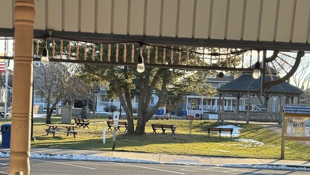 A gazebo with a metal roof and railings, overlooking a park with benches and a gazebo in the background. - Oceanside St. Rita Hotel Room  (Beach Haven)
