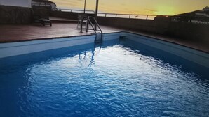 A swimming pool with a sunset in the background. - Rosa Amarilla Apartment (Puerto Rico)