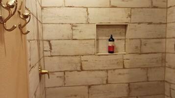 Chuveiro, toalhas de banho, sabonete, papel higiênico