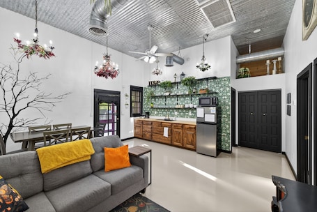 A modern kitchen with a green backsplash, wooden cabinets, and a stainless steel refrigerator.. Historic Firehouse converted to a 2-bedroom welcoming Downtown Chandler