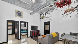 Una sala de estar moderna con sofá, televisor y mesa de comedor.