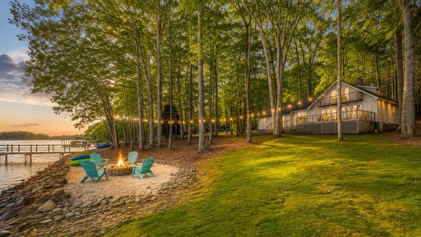 Un chalet au bord du lac, doté d’une terrasse, de meubles d’extérieur et d’un foyer.