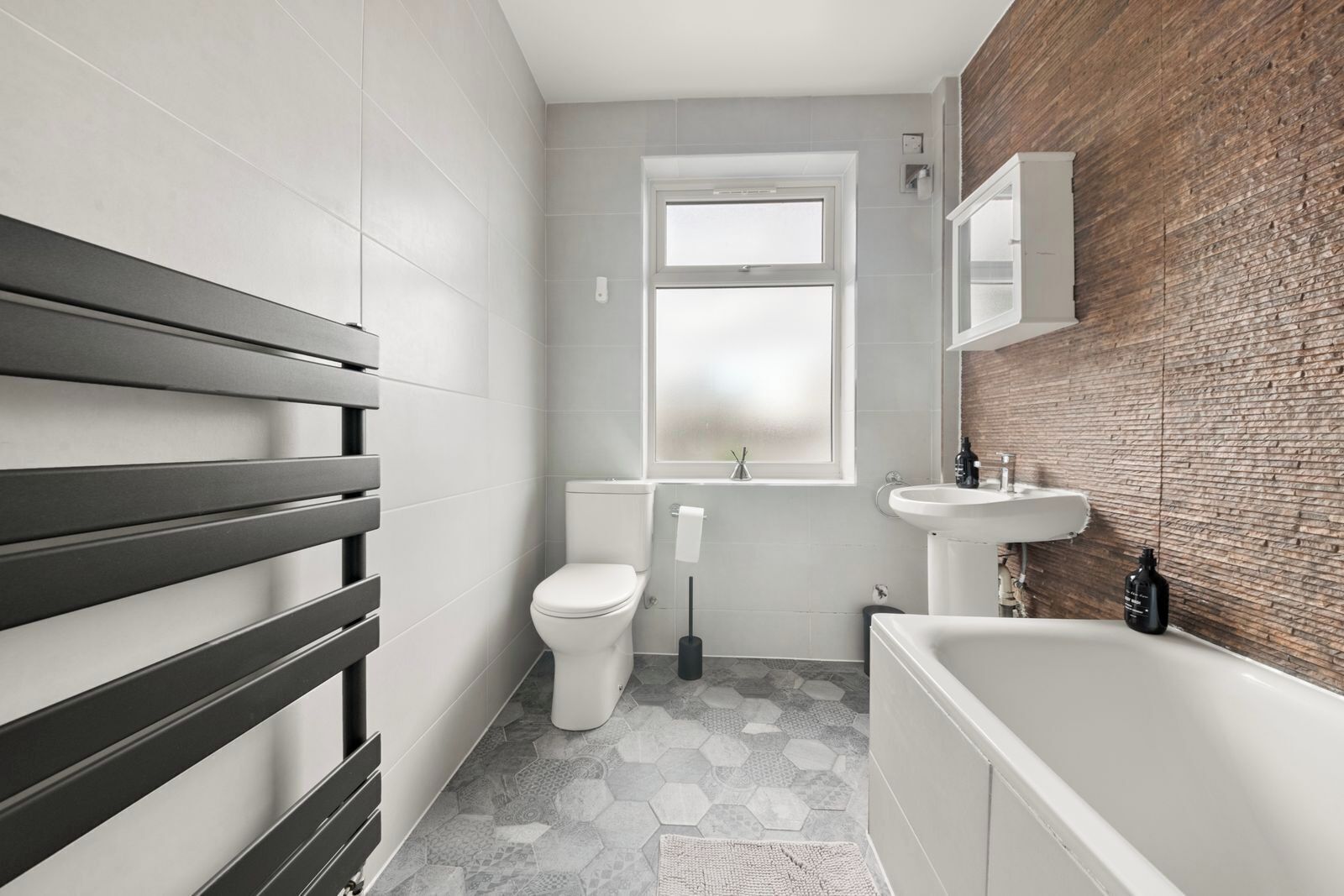 Un baño moderno con inodoro, lavamanos y bañera.