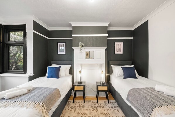 A double room with two beds, a fireplace, and a window.