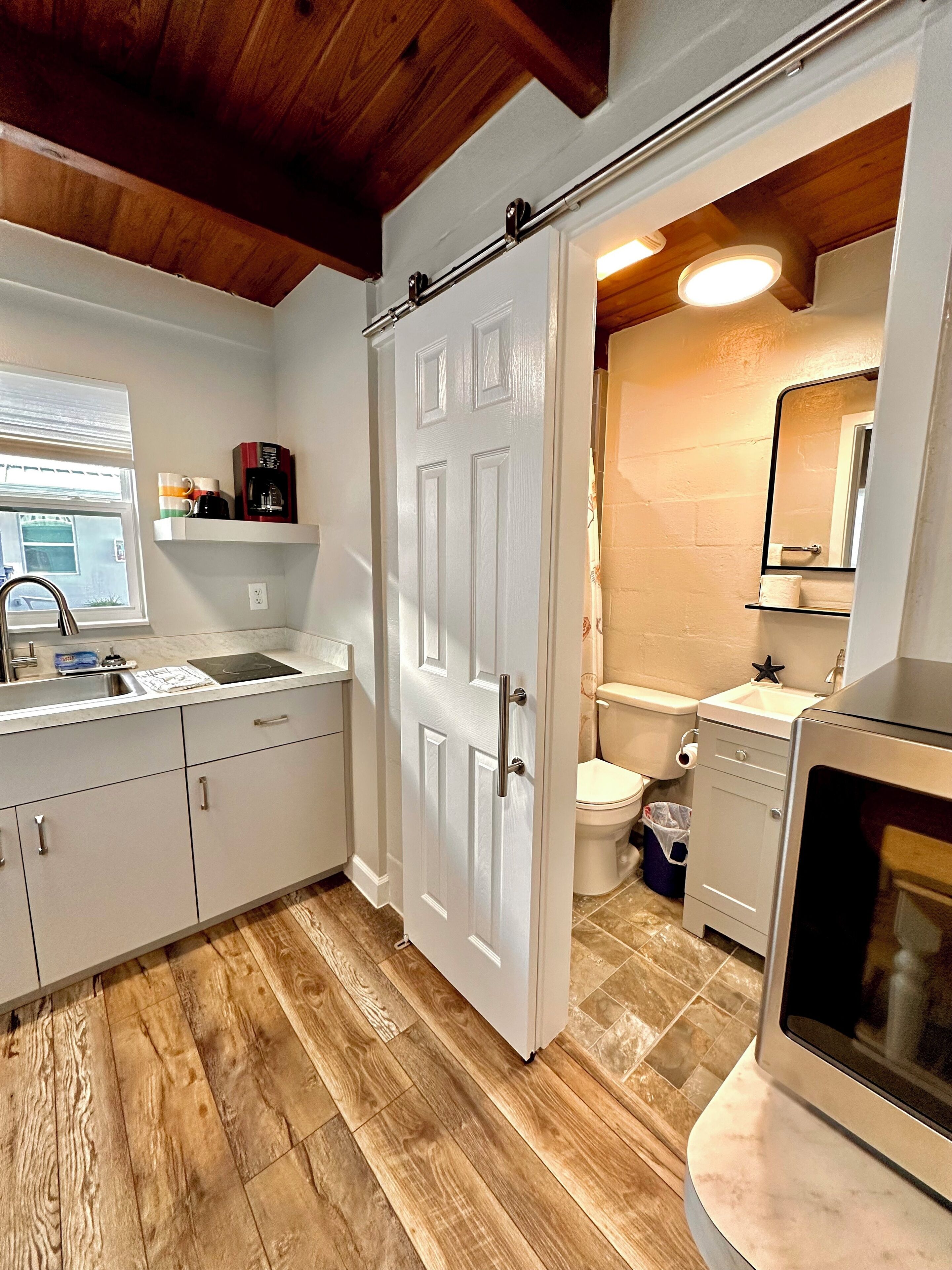 A compact kitchen with a white door, a sink, and a countertop.