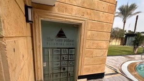 A staircase leading to a building entrance with a sign reading "The Giza palace Pyramids view."