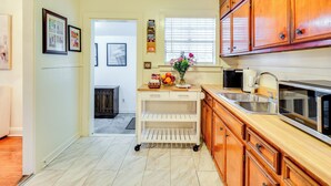 A kitchen with wooden cabinets, a stainless steel sink, and a countertop. - 3 Mi to Mississippi Stadium: Cozy Jackson Getaway! (Jackson)