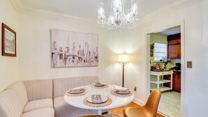 A dining area with a round table set for four, a sofa, and a chandelier. - 3 Mi to Mississippi Stadium: Cozy Jackson Getaway! (Jackson)