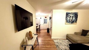 Un couloir comprenant un coin repas, un canapé et des œuvres d’art accrochées aux murs.