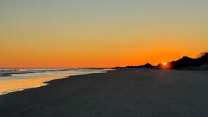 A beach at sunset with a clear sky and calm sea. - Modern, luxurious 1-bedroom condo in stunning Ocean Isle Beach (Ocean Isle Beach)