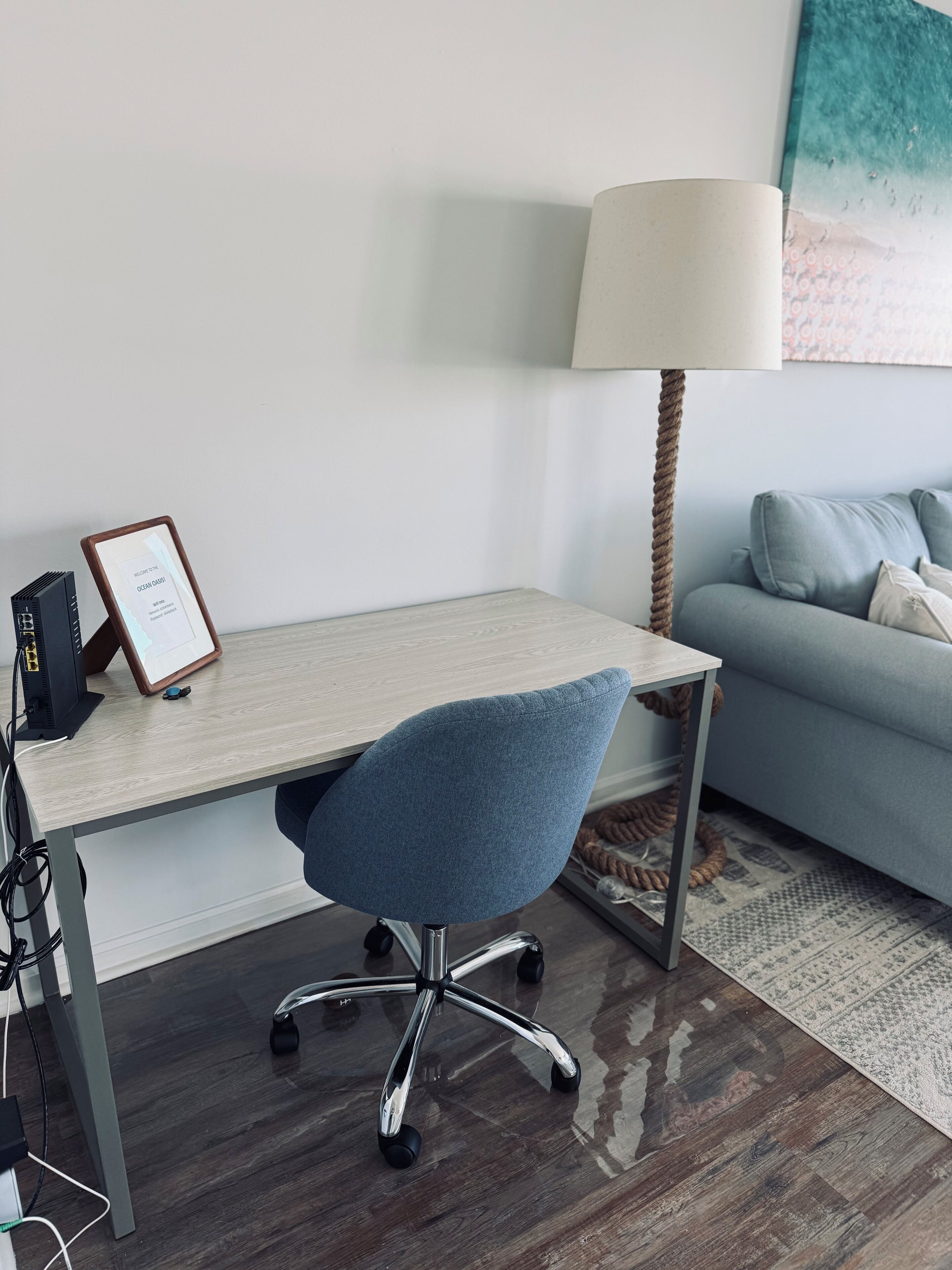 Een moderne kantoorruimte met een bureau, stoel, lamp en een bank.