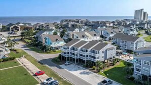 A coastal residential area with houses, a road, and a view of the ocean. - Modern, luxurious 1-bedroom condo in stunning Ocean Isle Beach (Ocean Isle Beach)