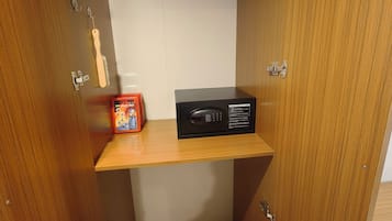 Un armario de madera con un estante, una cajita y un dispositivo electrónico negro.