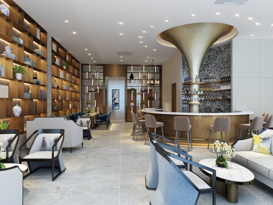 A modern bar area with a curved counter, seating with cushioned chairs, and a wall with shelves displaying books and decorative items.