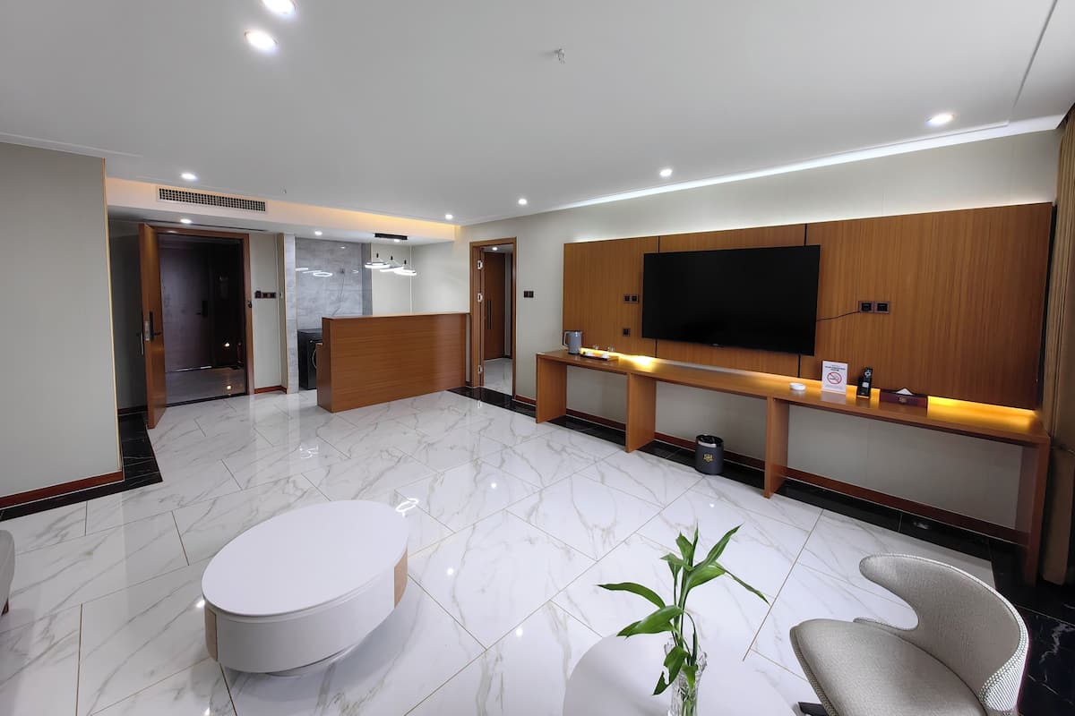 Suite estudio empresarial | Área de sala de estar | Televisión LCD de 75 pulgadas con canales digitales