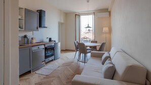 Un espace de vie compact comprenant une kitchenette, un coin repas et un canapé.