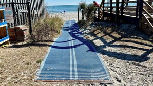 A beach path leading to the ocean, with a wooden fence and a stack of bricks on the left. - Ocean and sunrise views that have you coming back year after year! (Myrtle Beach)