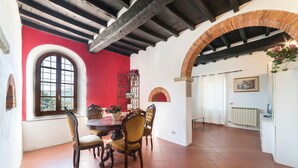 A dining area with a red wall, a wooden ceiling, and a tiled floor. - 6 bedroom amazing home in Dicomano (Dicomano)