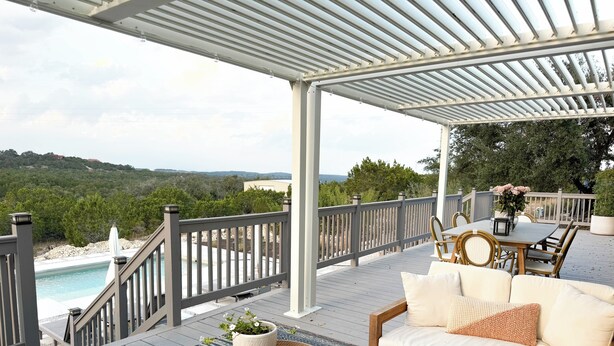 A covered outdoor deck with a pool, a sofa, and a dining table. - Designer Luxury Cottage with Saltwater Pool on Private 4 Acres (Johnson City)