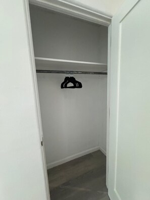 Un armario con una barra para colgar y un estante.