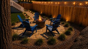 A backyard patio with a fire pit, outdoor seating, string lights, and a wooden fence. - Closest to Springville Ranch & Gateway to the Sequoias•Pet Friendly•Sleeps 10 (Springville)