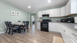 A modern kitchen with white cabinets, a black stove, and a granite countertop. - Closest to Springville Ranch & Gateway to the Sequoias•Pet Friendly•Sleeps 10 (Springville)