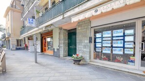 Eine Straße mit einer Reihe von Gebäuden, darunter ein Geschäft mit einem Schild für Zanetti Immobiliere.