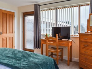 A bedroom with a bed, a desk with a computer, a chair, and a dresser. - 3 bedroom accommodation in Carnforth (Carnforth)