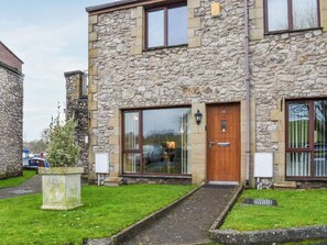 A stone building with a wooden door and large windows. - 3 bedroom accommodation in Carnforth (Carnforth)