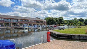 A canal with boats docked, a red post box, and a building with large windows. - 3 bedroom accommodation in Carnforth (Carnforth)